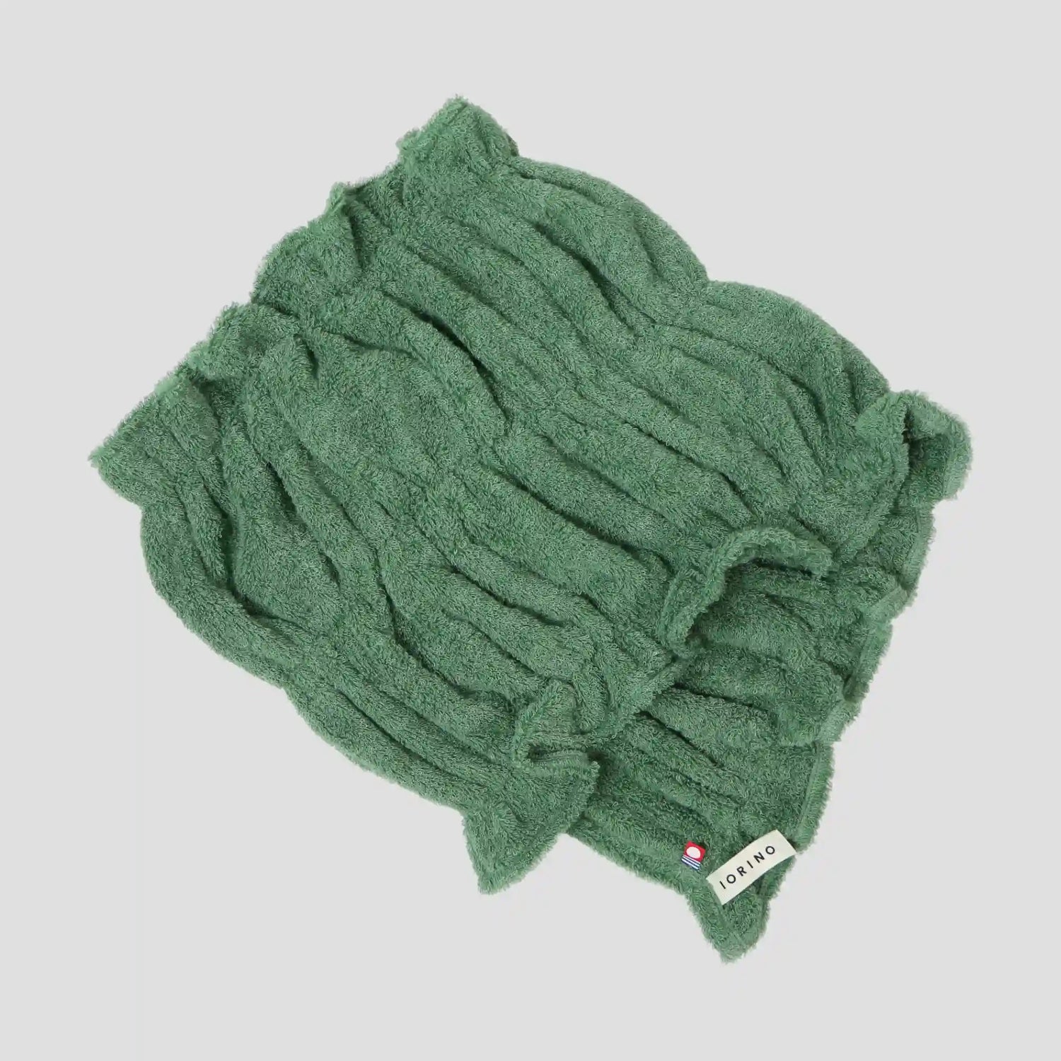 Green Imabari towel with a brand label on a light gray background