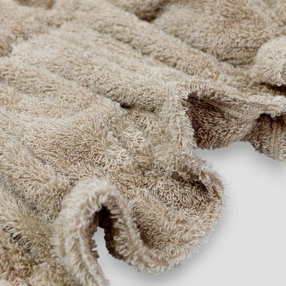 Close-up of a beige textured Imabari towel on a white background