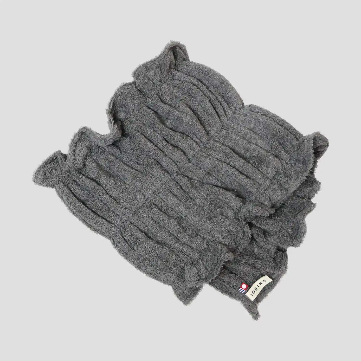 Gray Imabari towel with a brand label on a light gray background