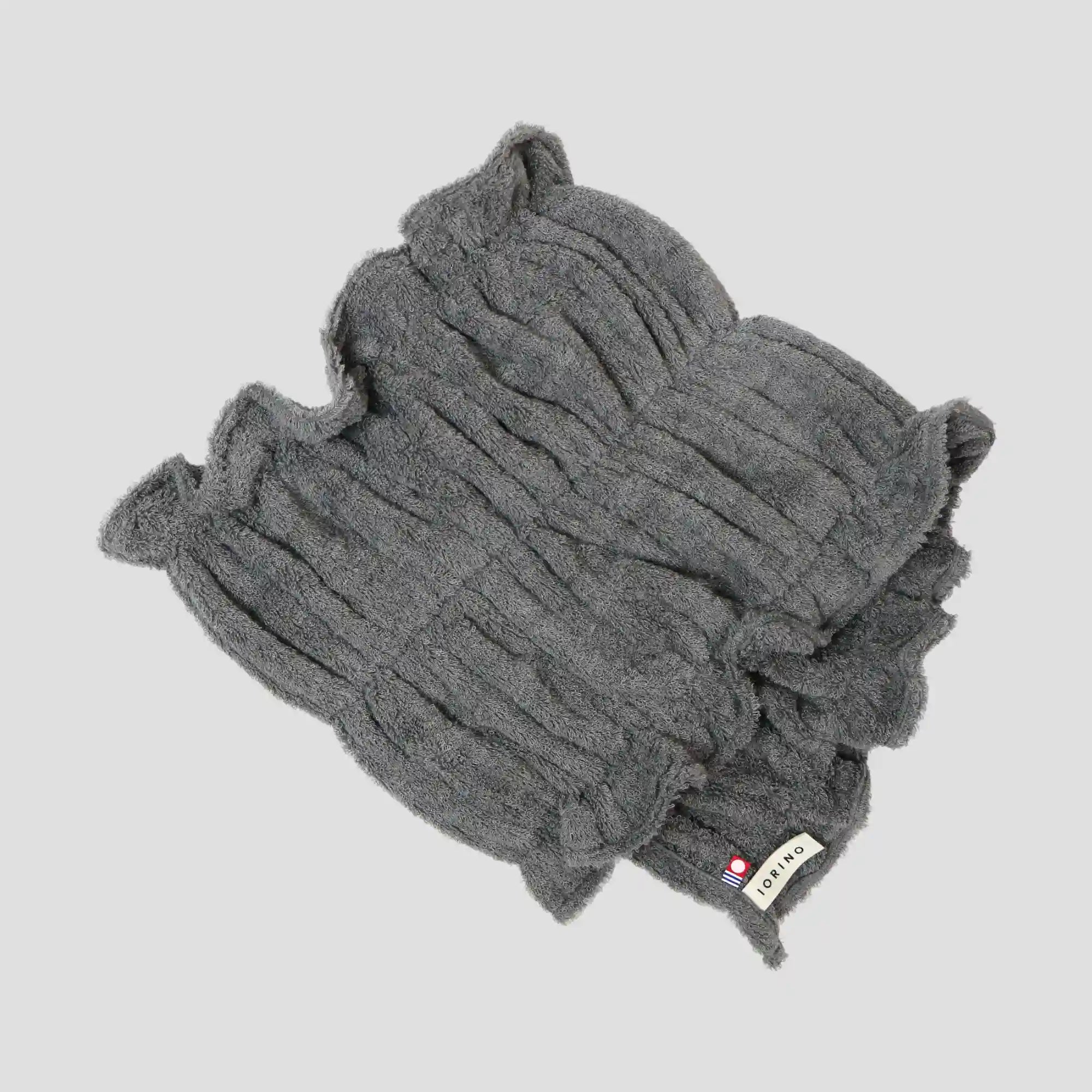 Gray Imabari towel with a brand label on a light gray background