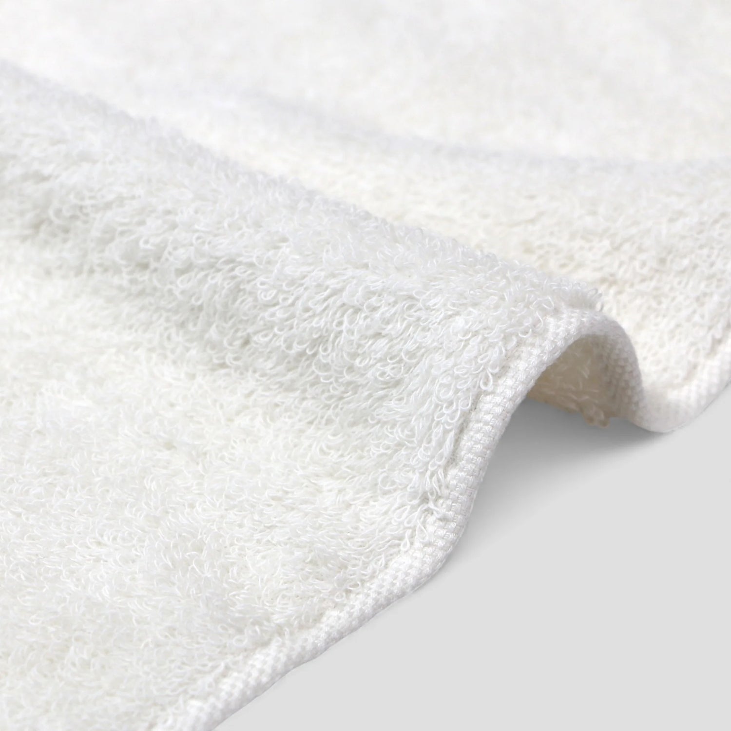 Close-up of a white Imabari towel on a light gray background