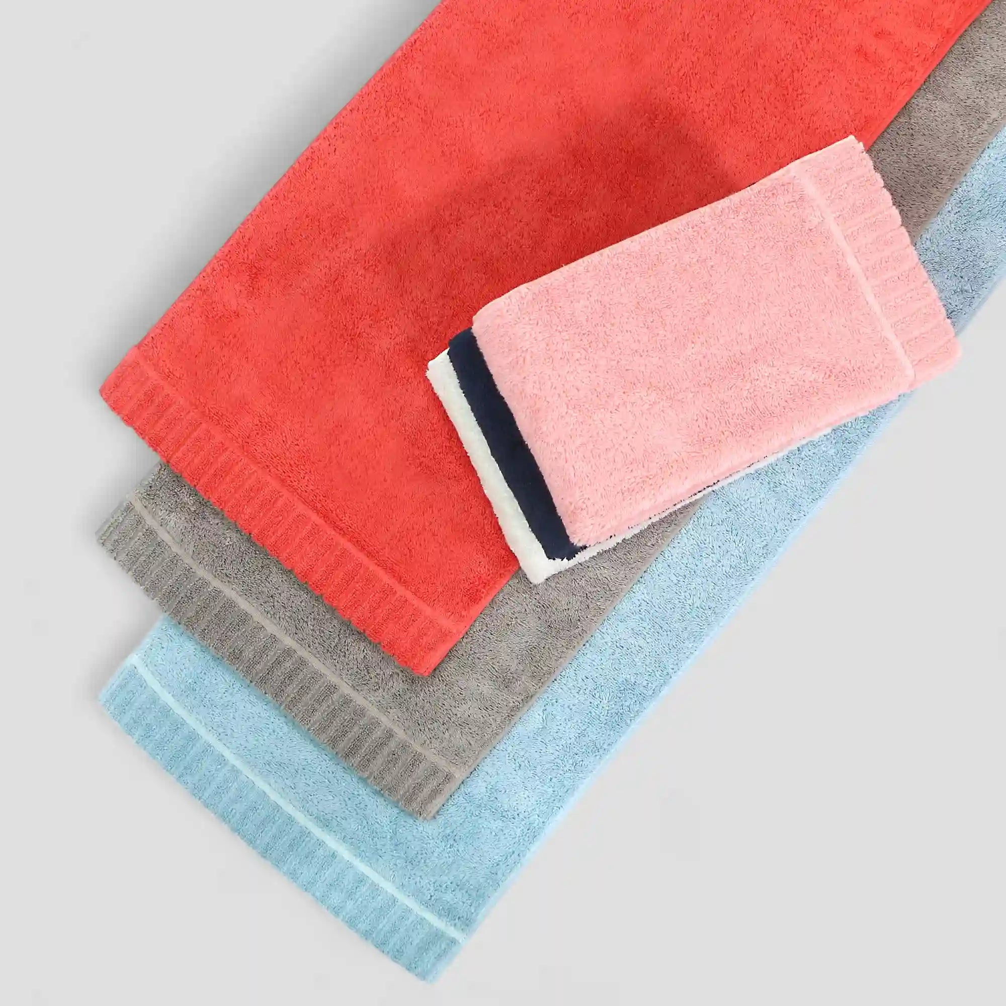Stack of colorful Imabari towels on a light gray background