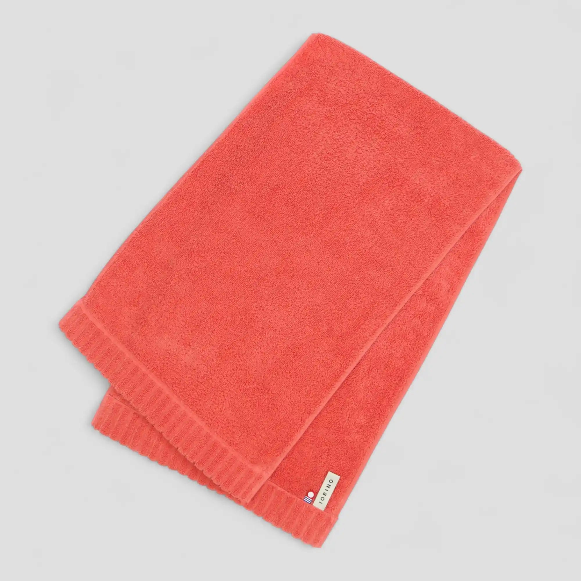 Folded red Imabari towel on a gray background