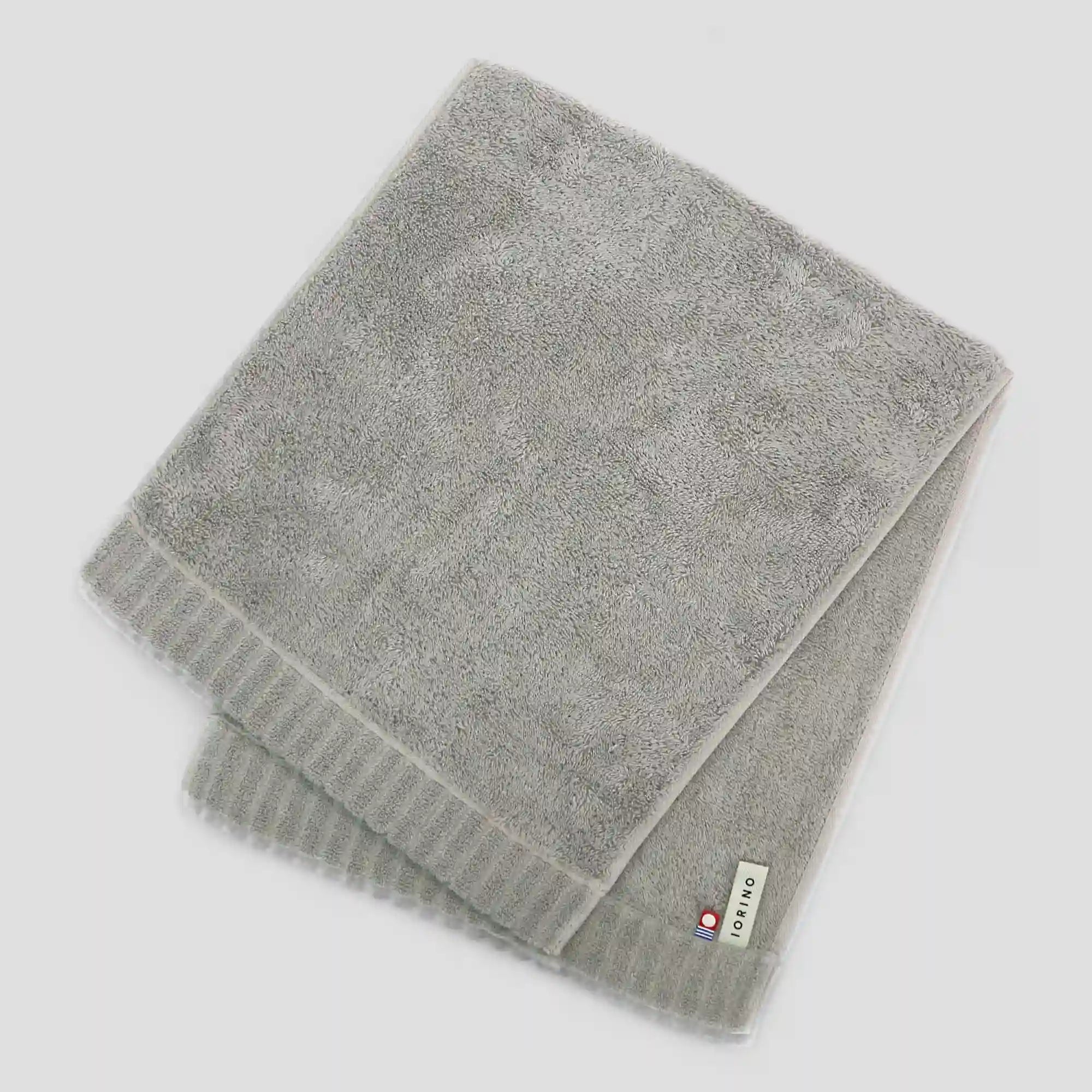 Gray Imabari towel with a brand label on a light gray background