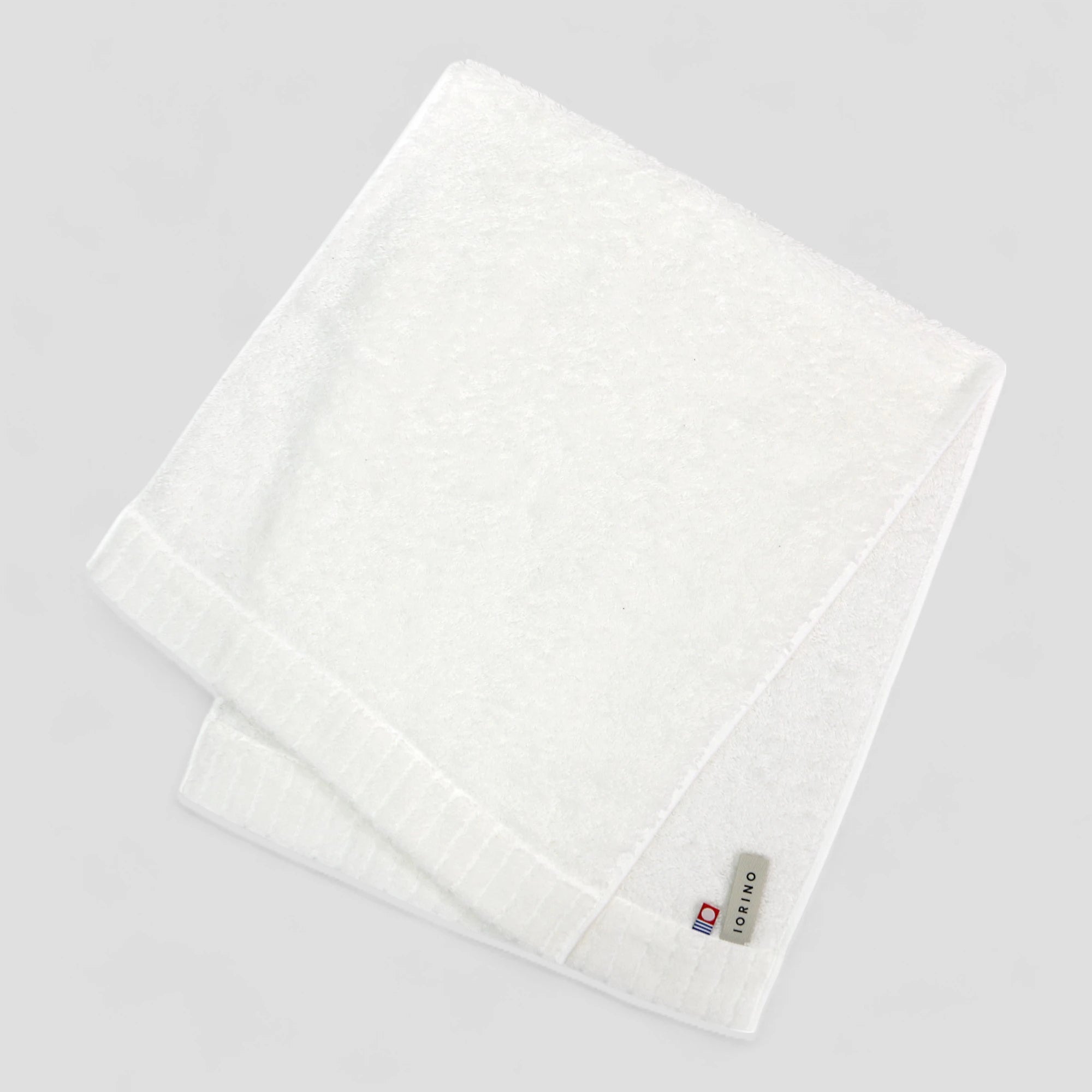 White Imabari towel with a brand label on a light gray background