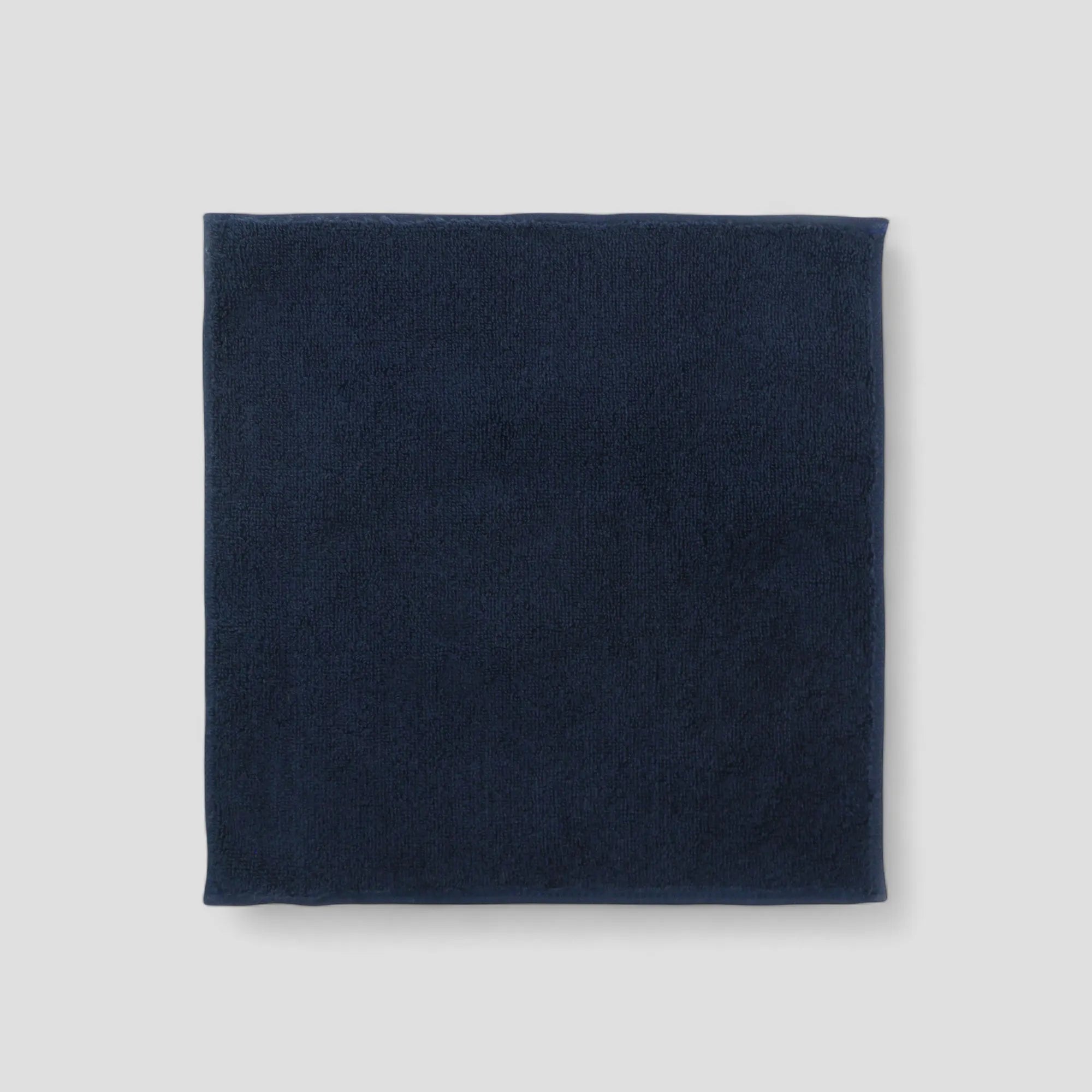 Navy blue Imabari towel on a light gray background