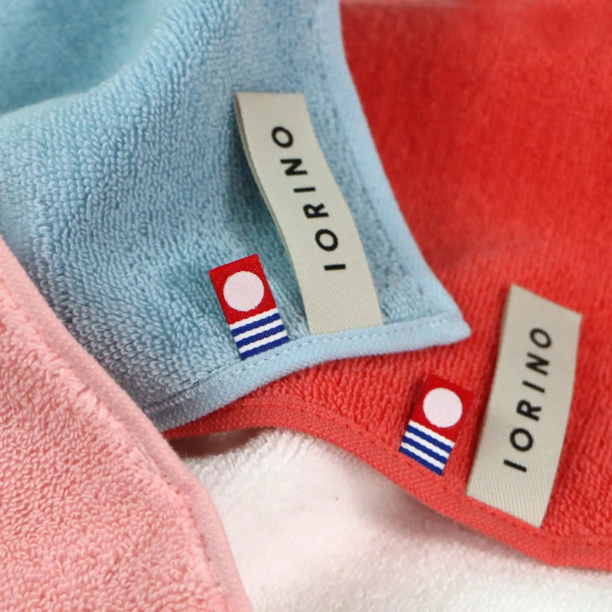 Close-up of IORINO branded Imabari towels in various colors with visible labels.