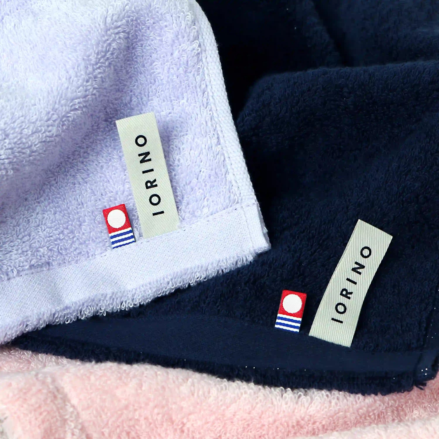 Close-up of IORINO branded Imabari towels in various colors with visible tags.