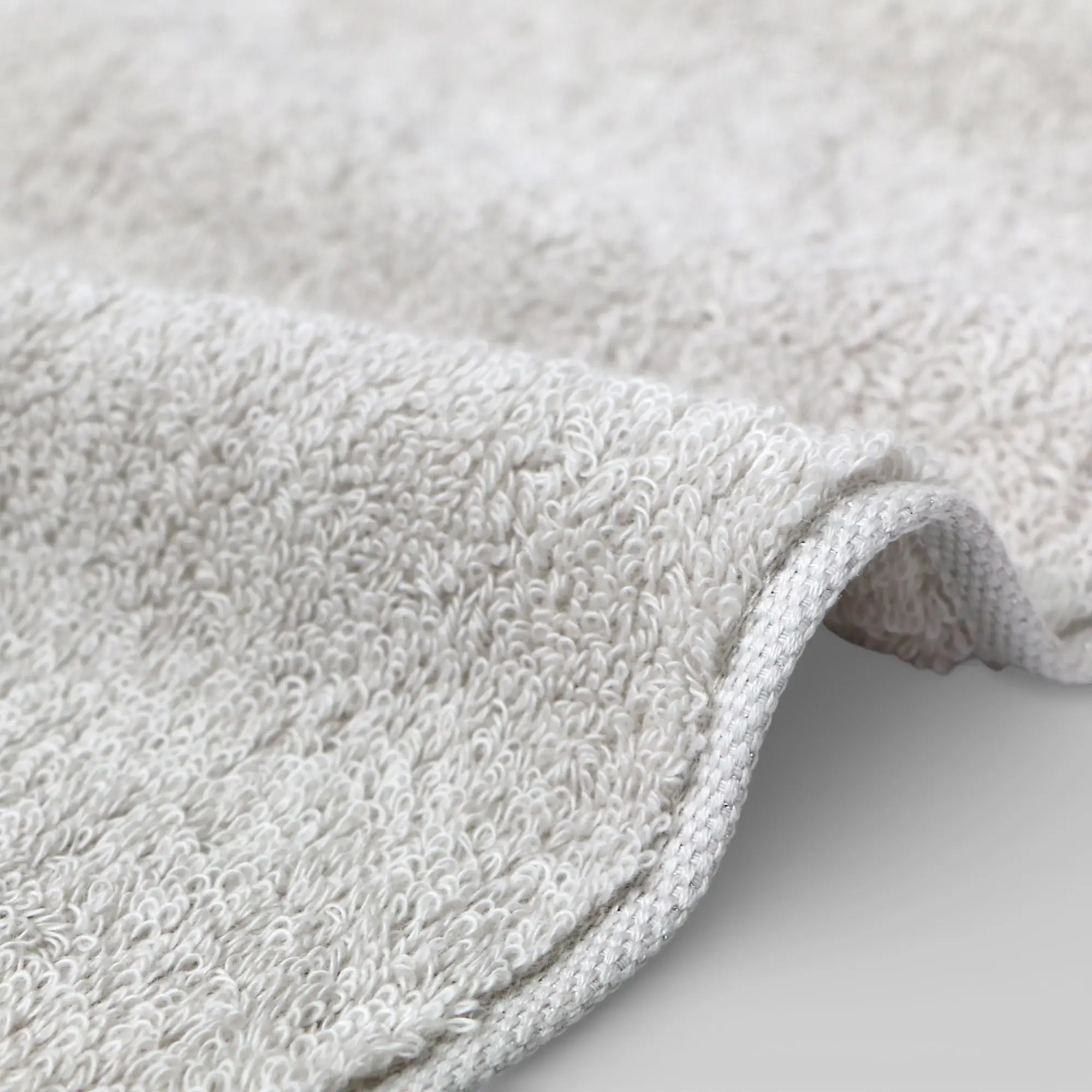 Close-up of a textured gray Imabari towel on a light gray background