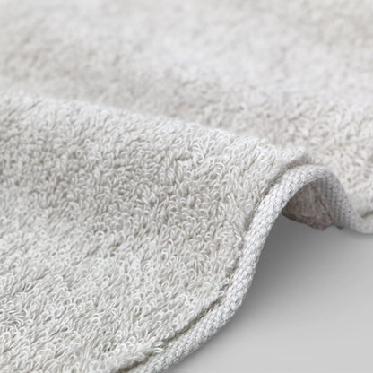 Close-up of a textured gray Imabari towel on a light gray background
