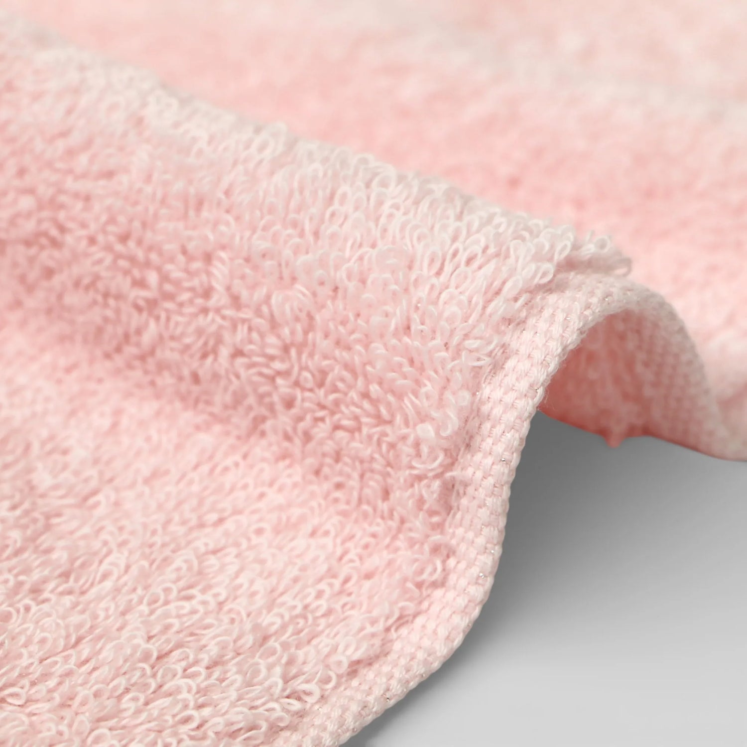 Close-up of a pink Imabari towel textured fabric on a light gray background