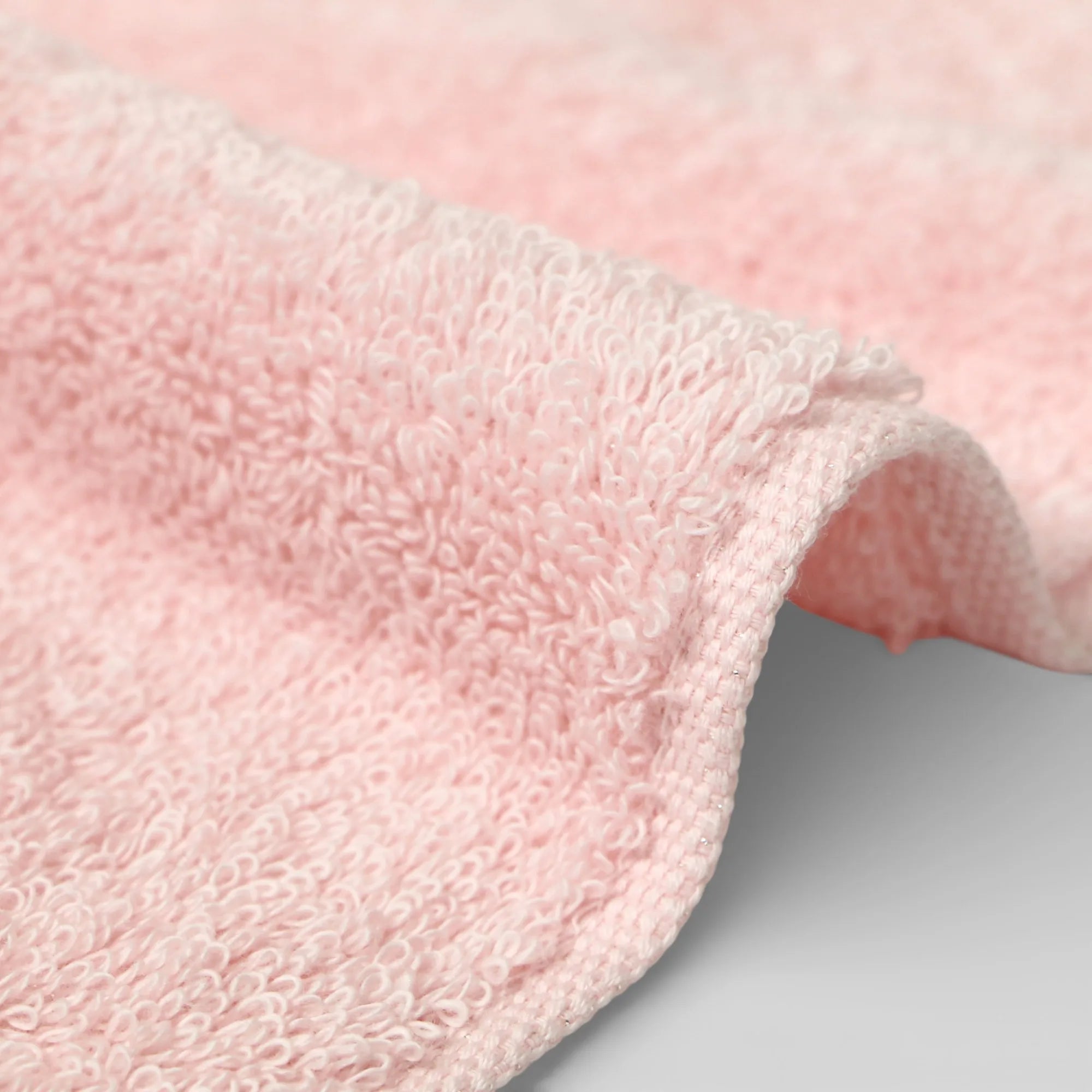 Close-up of a pink Imabari towel textured fabric on a light gray background