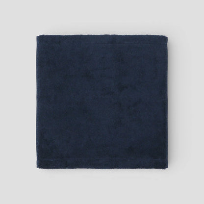 Navy blue fabric square Imabari towel on a light gray background