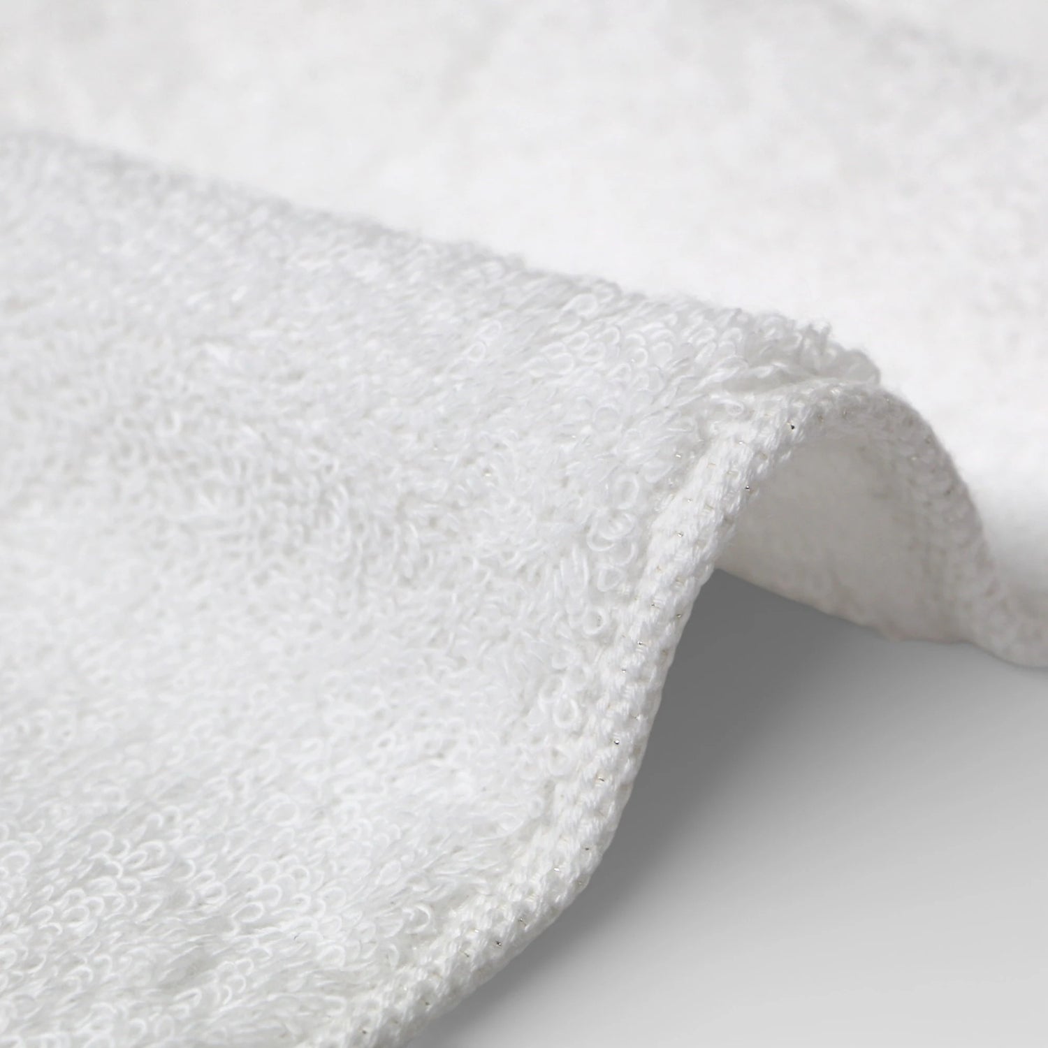Close-up of a white Imabari towel textured fabric on a light gray background