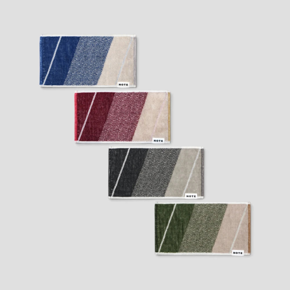 Four rectangular layer Imabari towels arranged diagonally on a light gray background. The towels feature diagonal stripes in various color combinations: navy, blue, and beige; red, burgundy, and beige; black, gray, and beige; and olive green, gray, and beige.