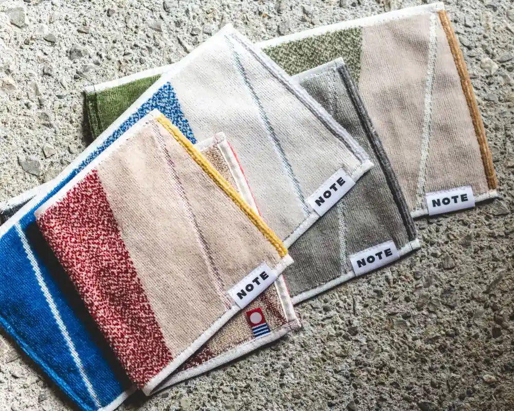 Five small Imabari towel fabric square pieces with visible &