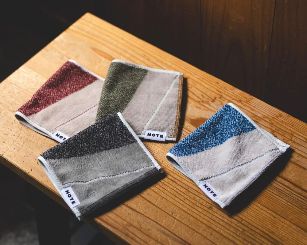 Four rectangular layer Imabari towels arranged diagonally on the wood table