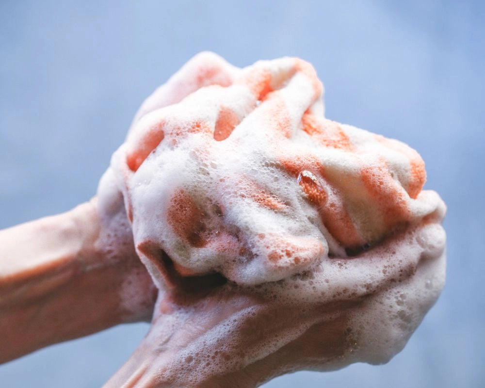 Hand holding a Imabari towel with soft bubble of soap against a blurred background