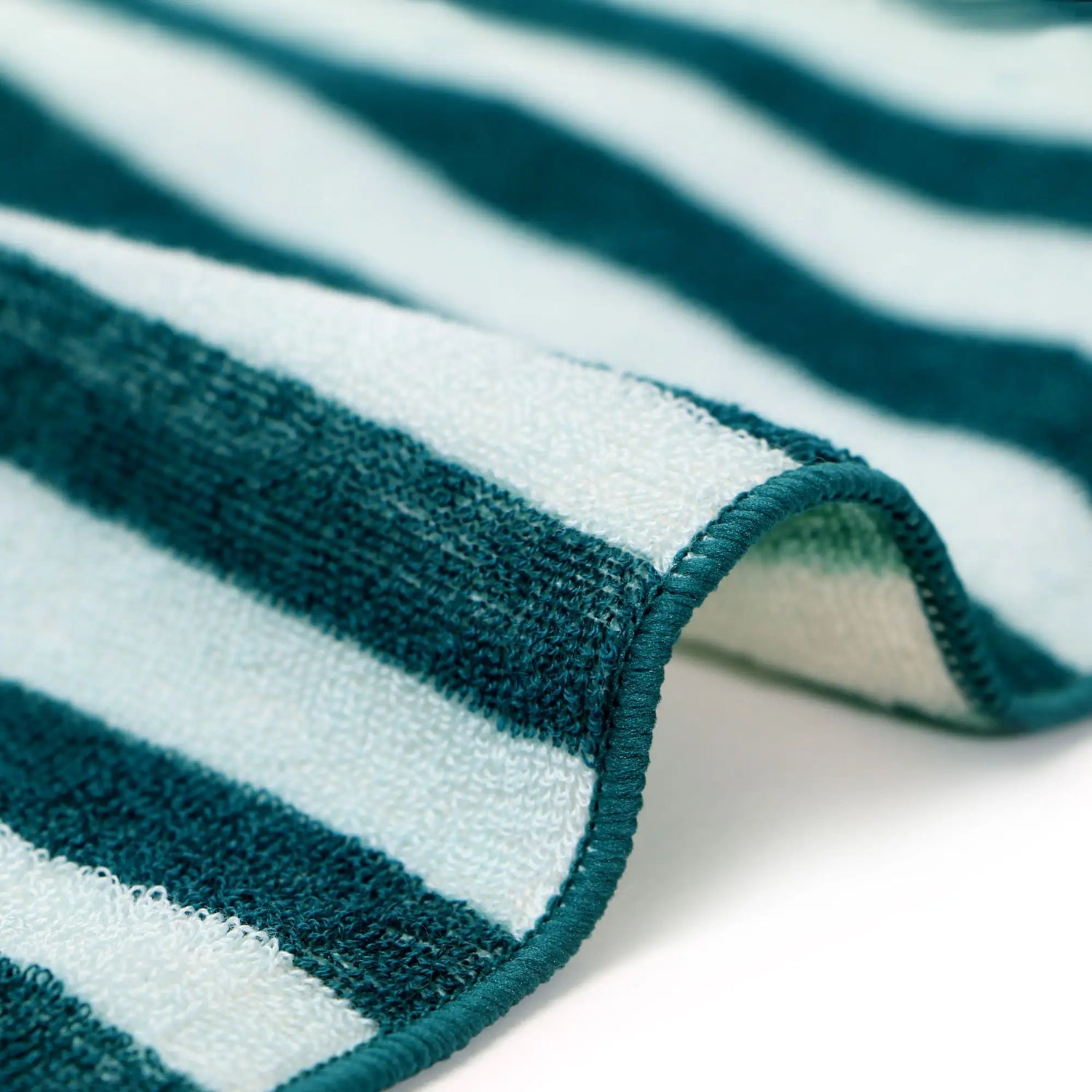 Close-up of a green and white striped Imabari towel on a white background