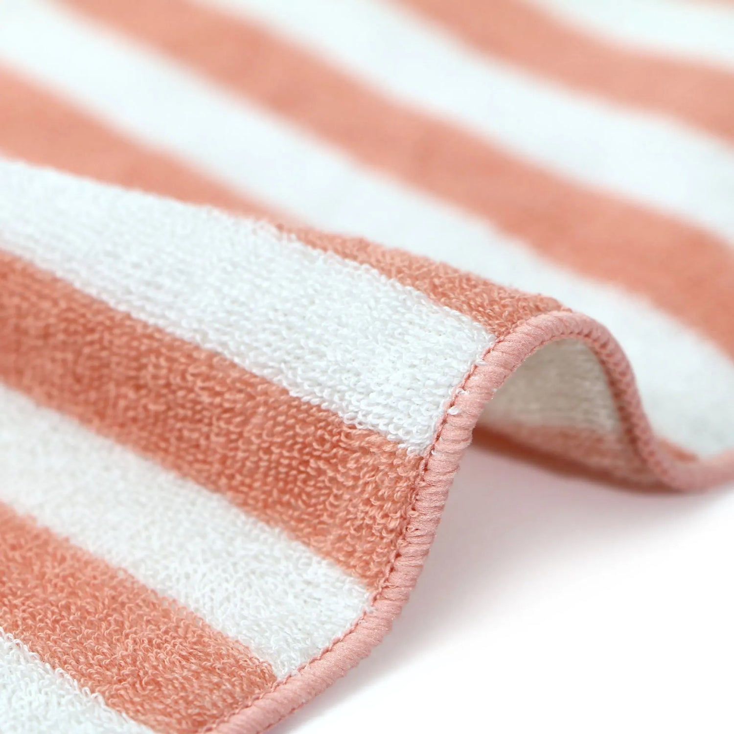 Close-up of a striped  Imabari towel with pink and white horizontal stripes on a light background