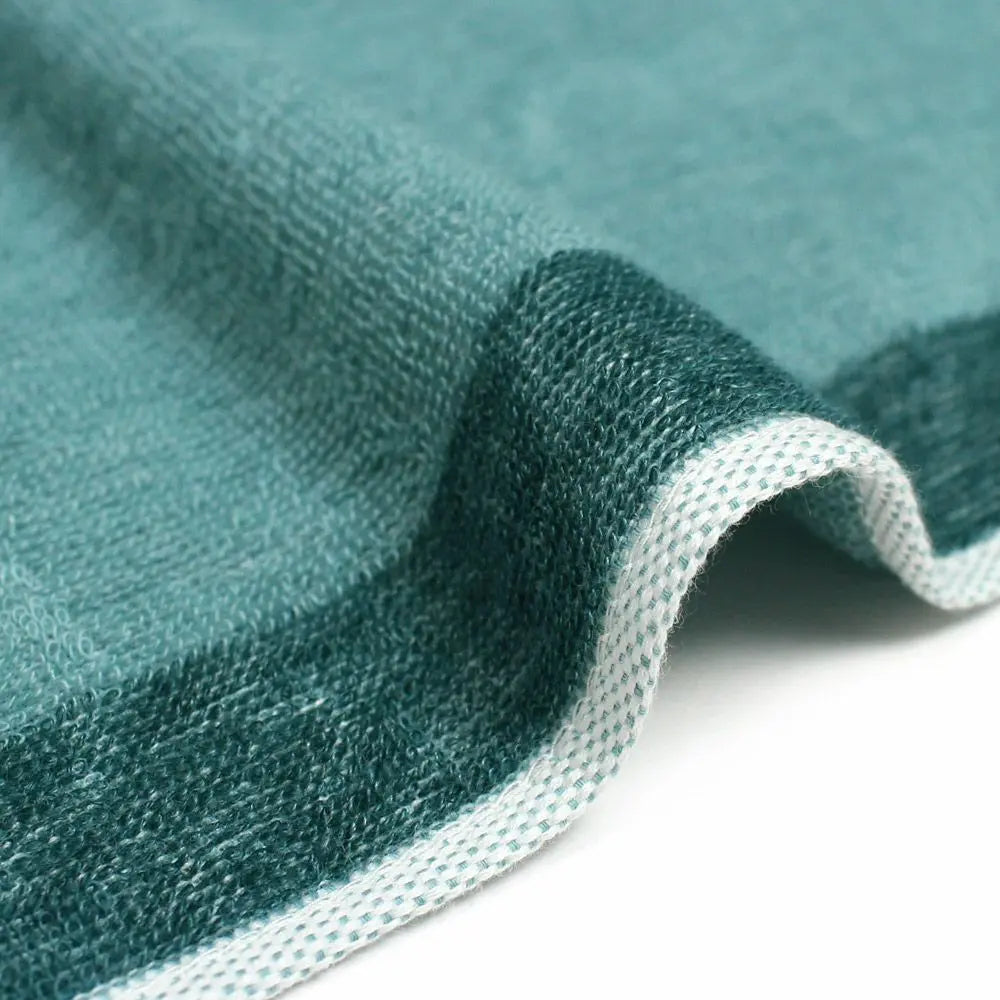 A close-up of the texture and side of a reversible green Imabari towel