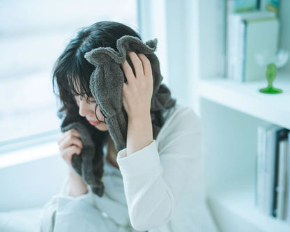 Person with a gray Imabari towel wrapped around their head in a bright room