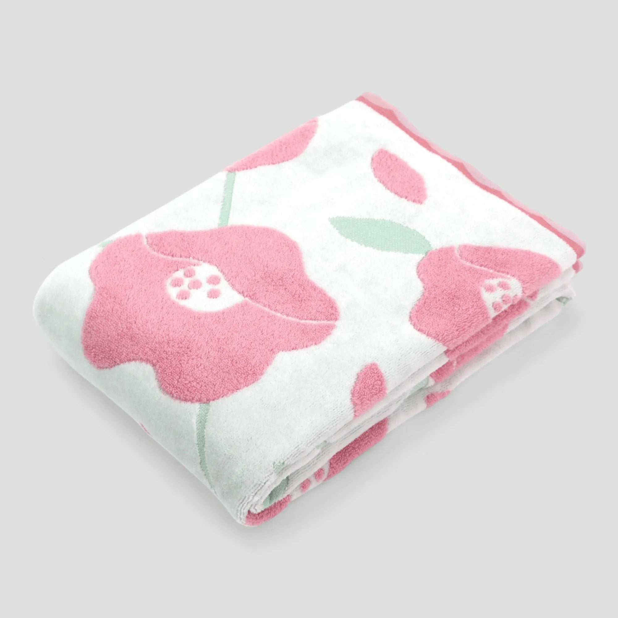 Folded Imabari towel with pink floral pattern on a light gray background