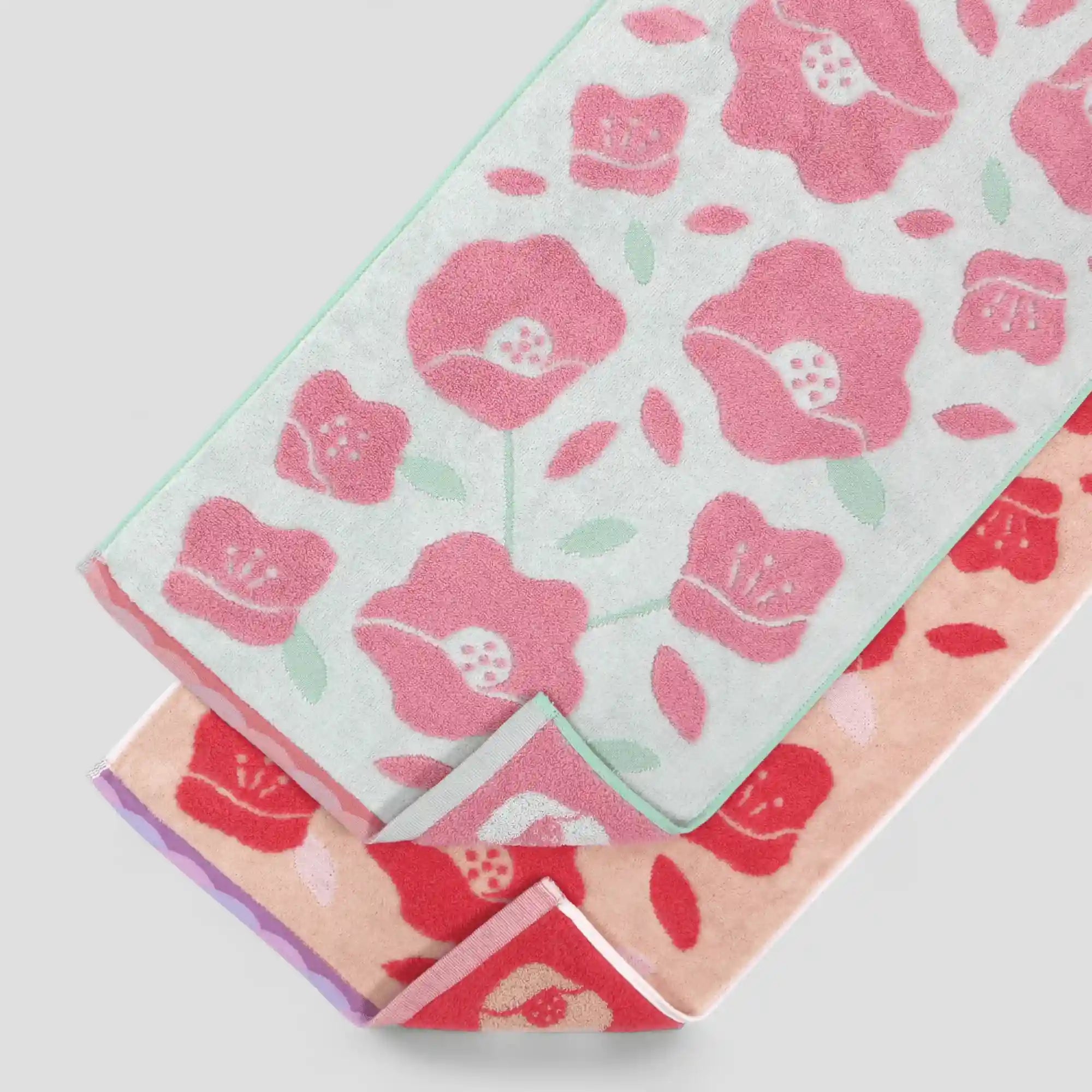 Stack of floral-patterned Imabari towels   on a light gray background