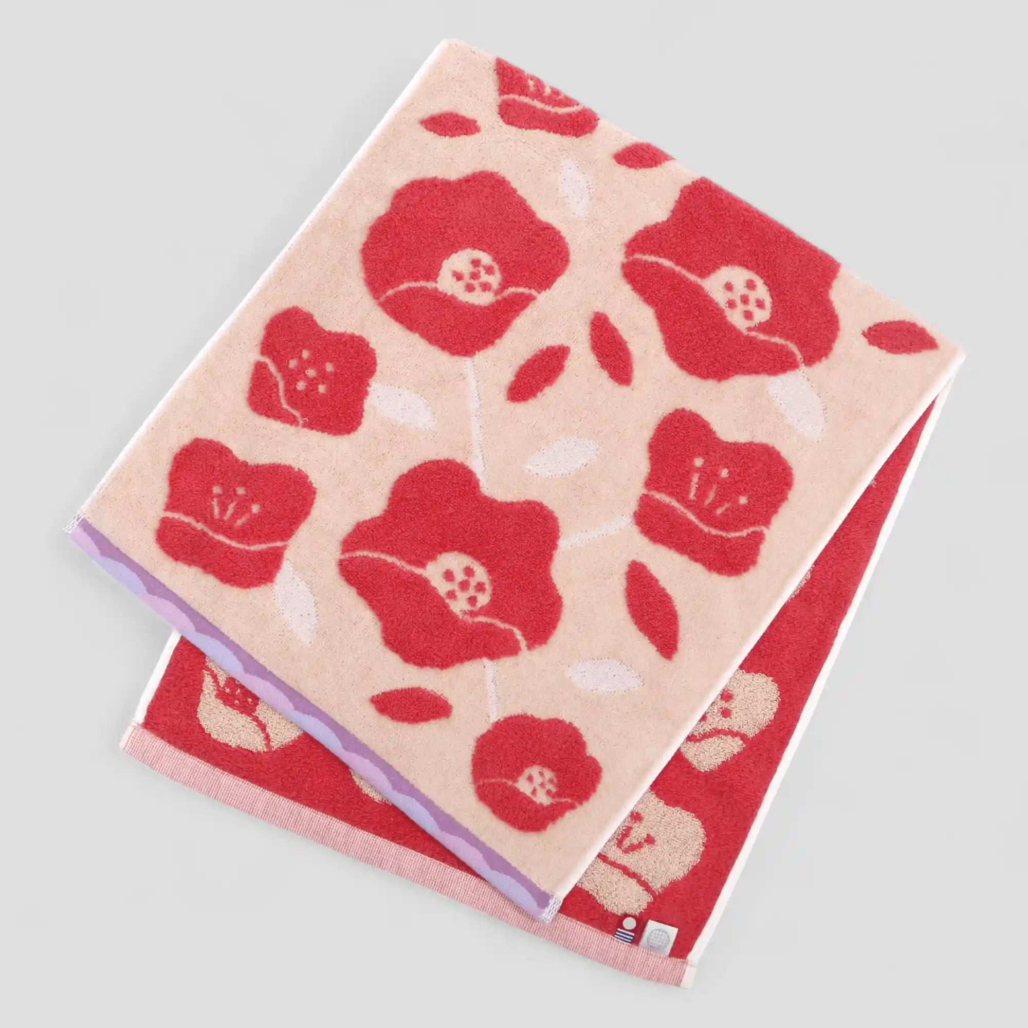 Red floral patterned Imabari towel on a light gray background