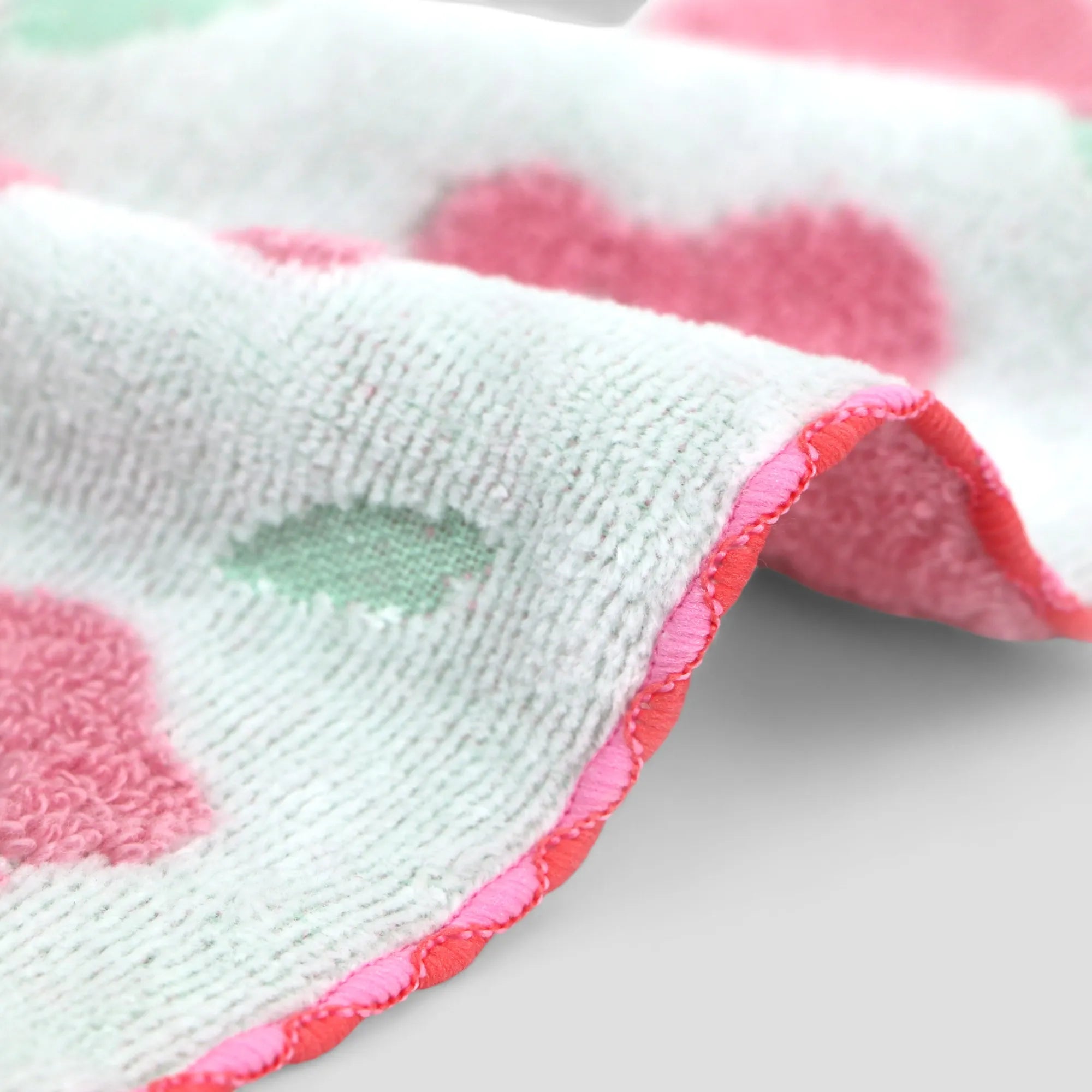 Close-up of Imabari towel side, pink and white patterned fabric with a textured surface.