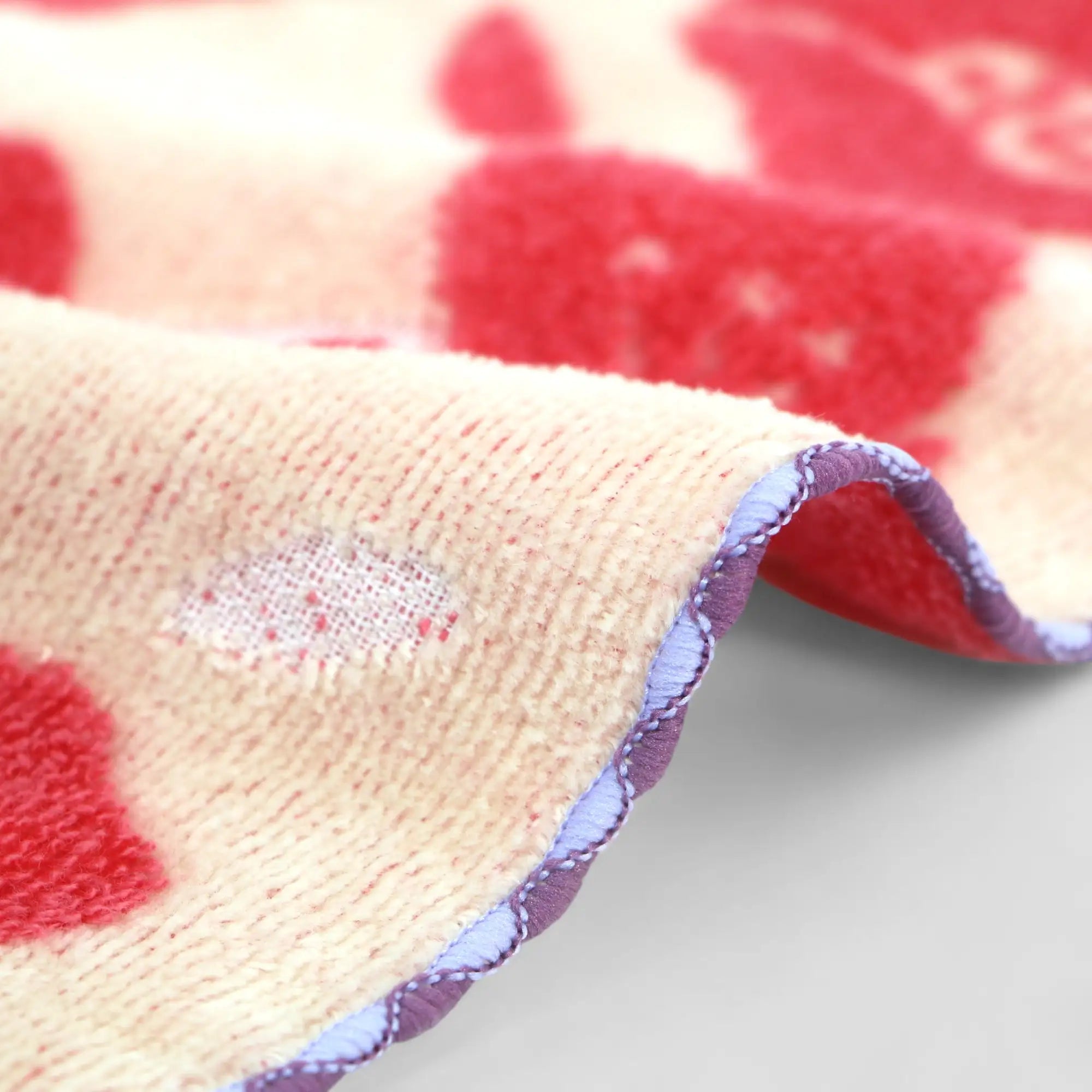 Close-up of Imabari towel side, red and beige patterned fabric with a textured surface