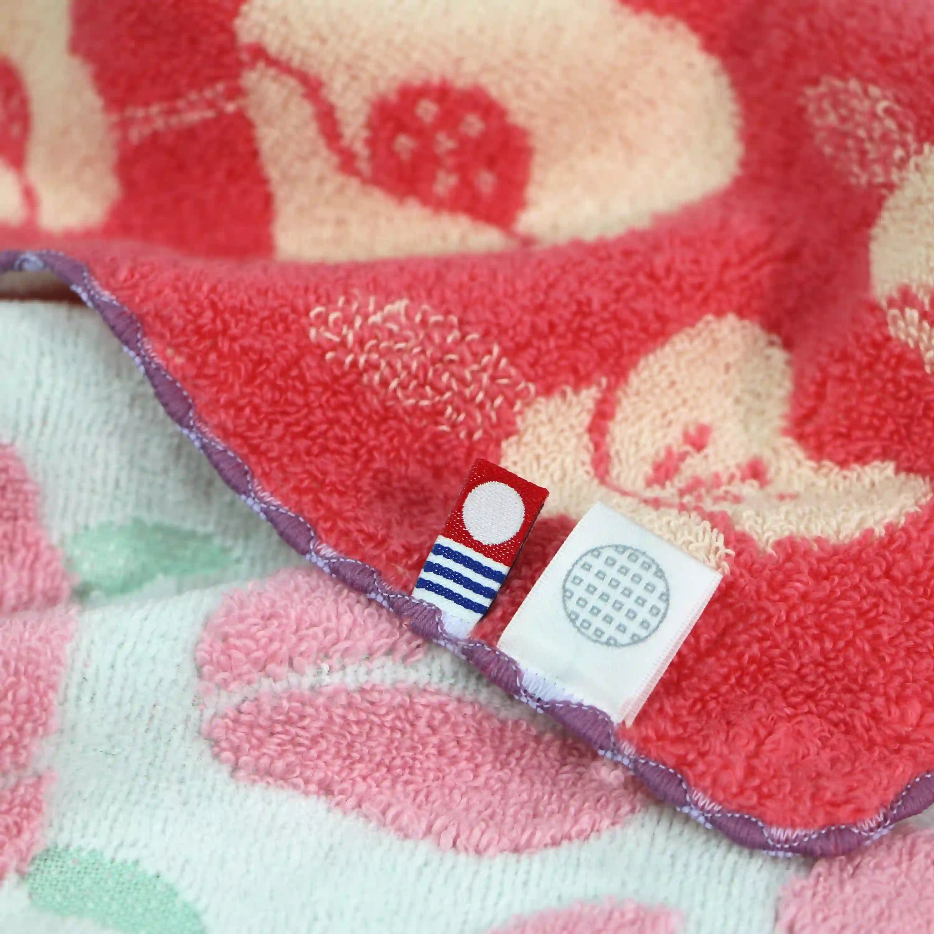 Floral-patterned Imabari towel with a brand label on a textured surface