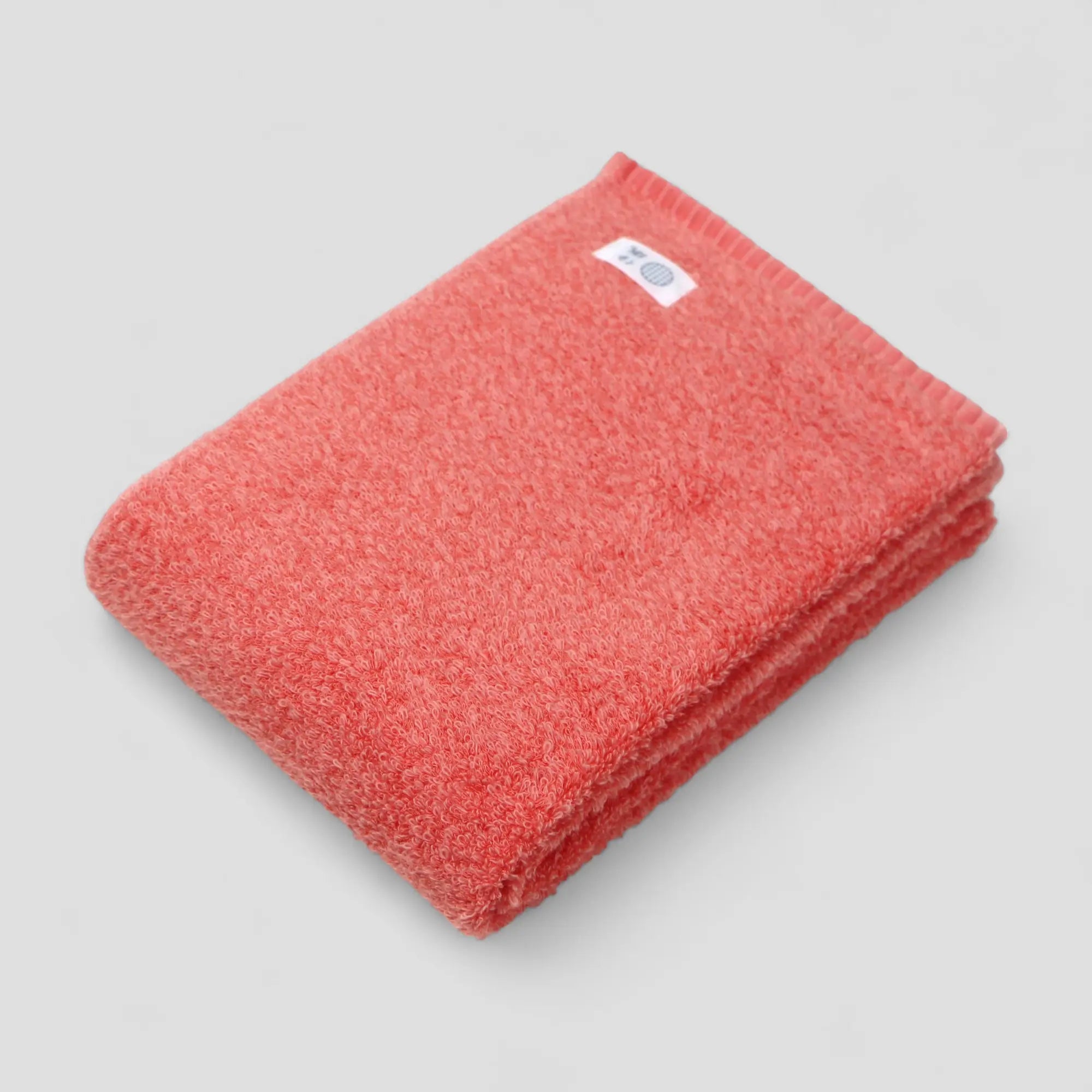 Red Imabari towel with a label on a light gray background