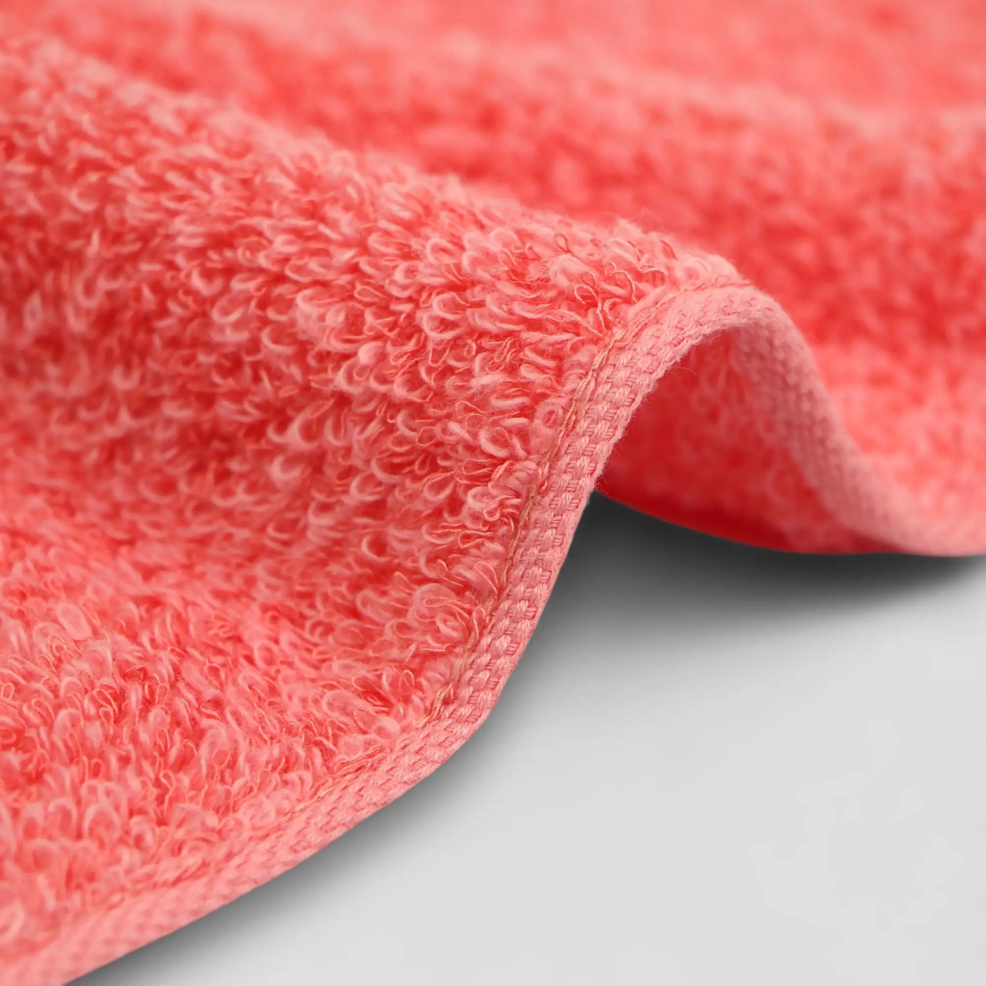 Close-up of a textured red Imabari towel fabric on a light gray background