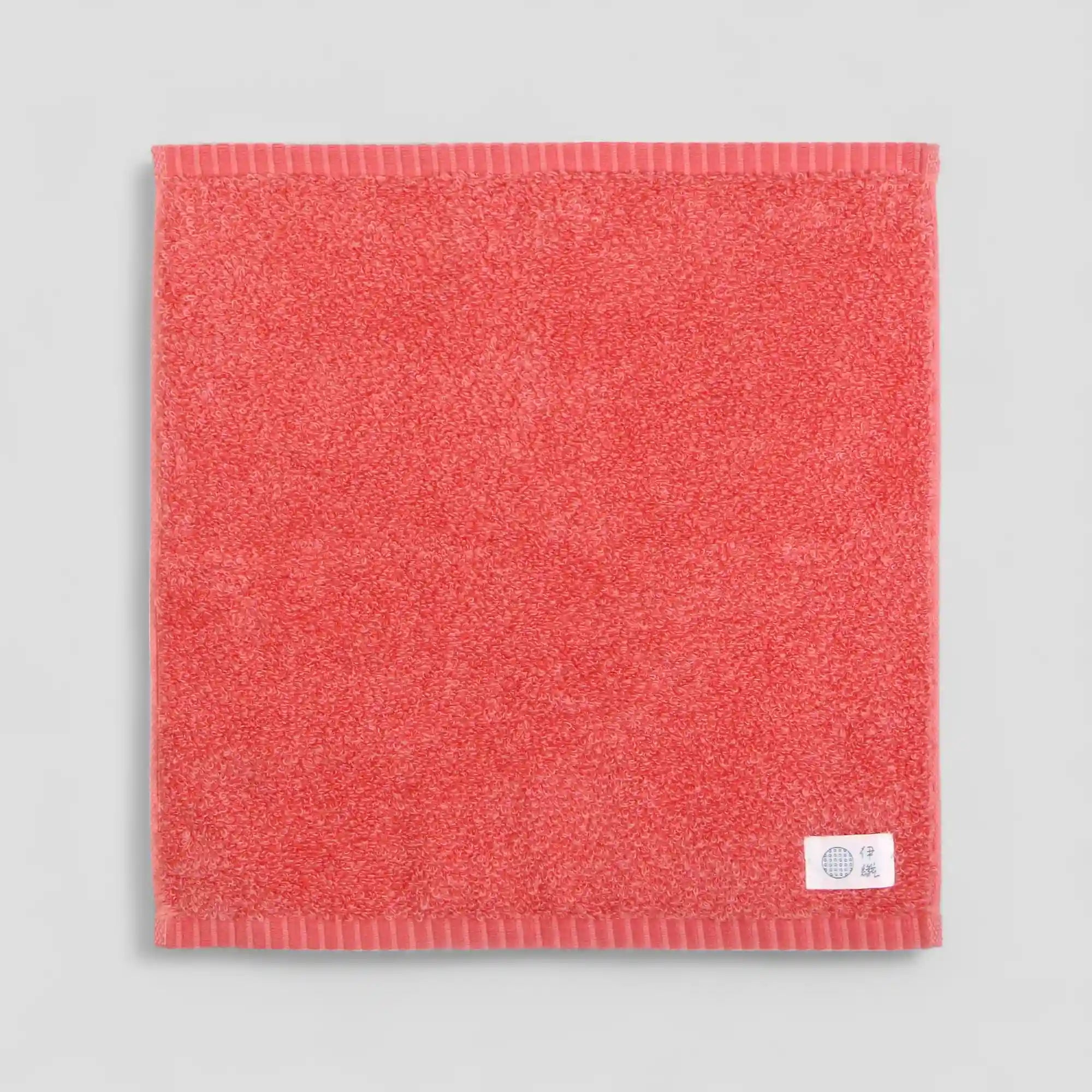 Red Imabari towel with a brand label on a gray background