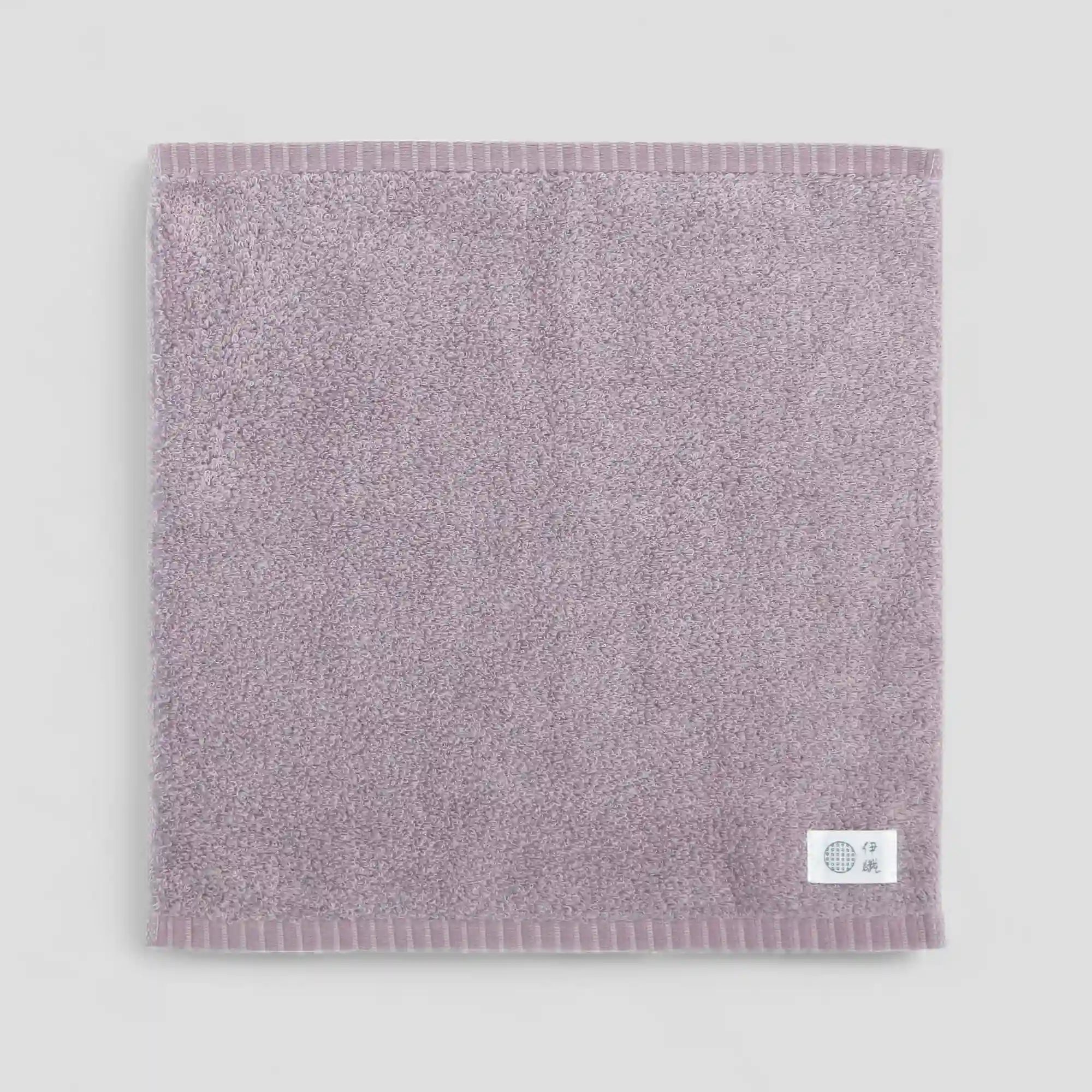 Purple Imabari towel with a brand label on a light gray background
