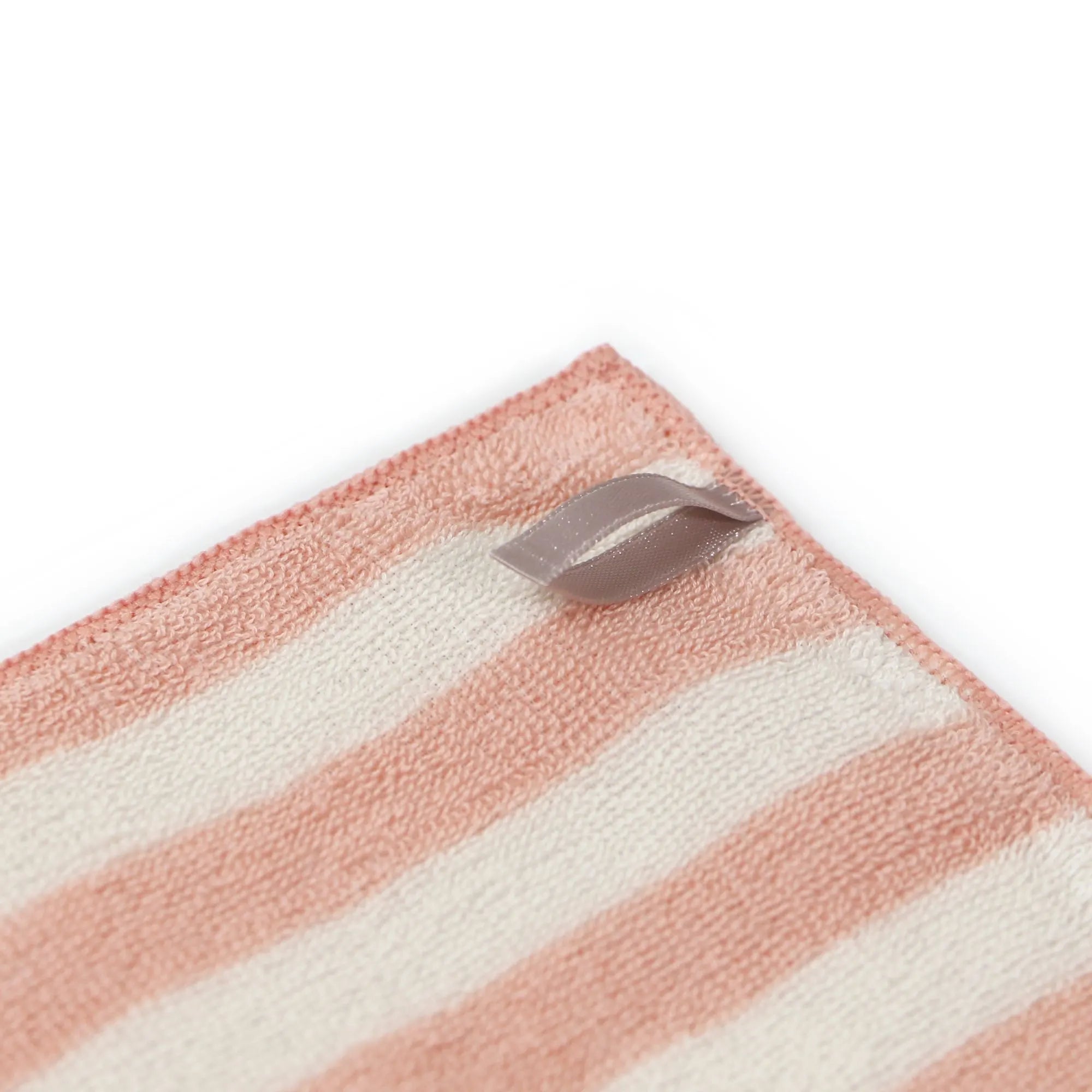 Striped pink and white Imabari towel with a metallic tag on a white background