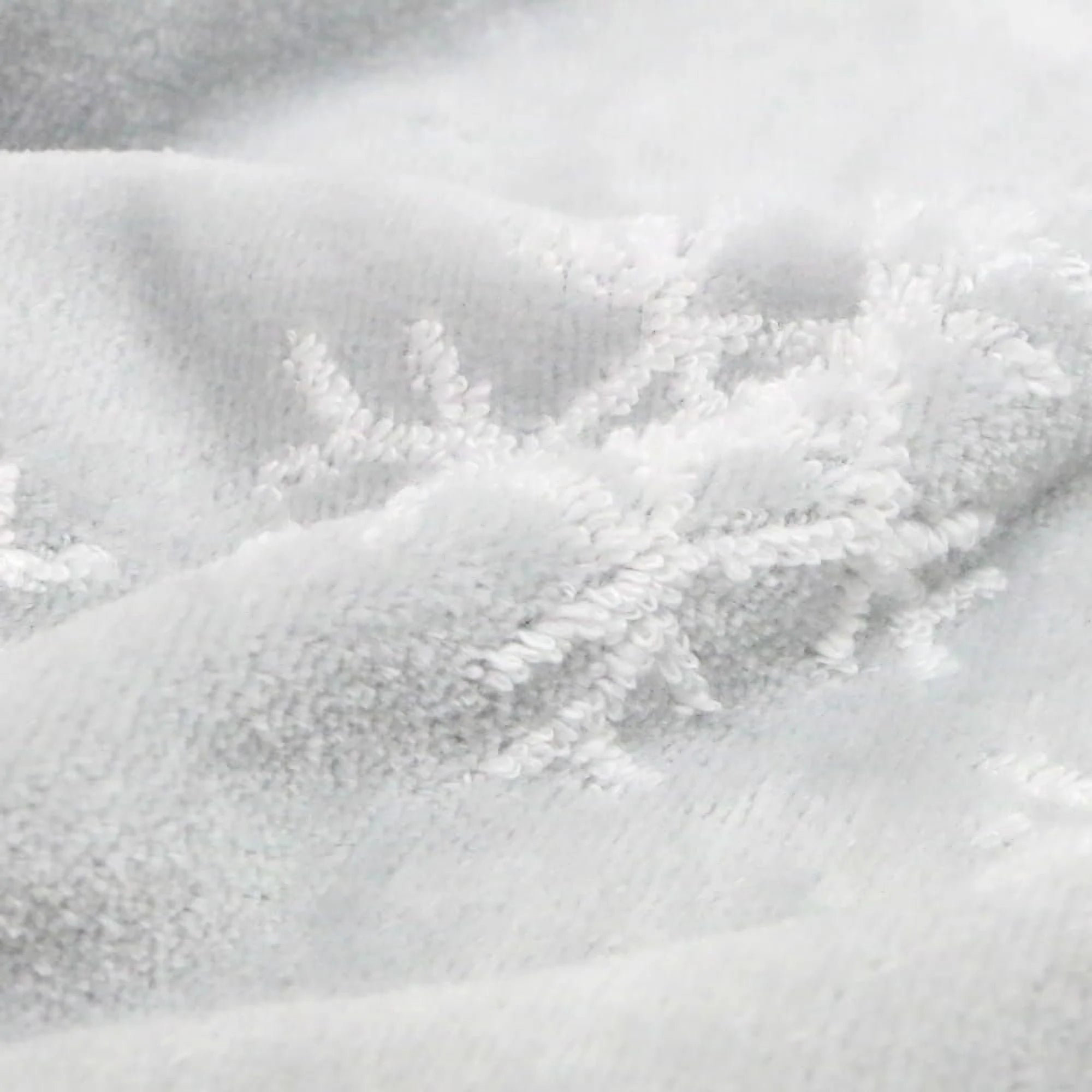 Close-up of a light gray Imabari towel with snowflake pattern textured fabric.
