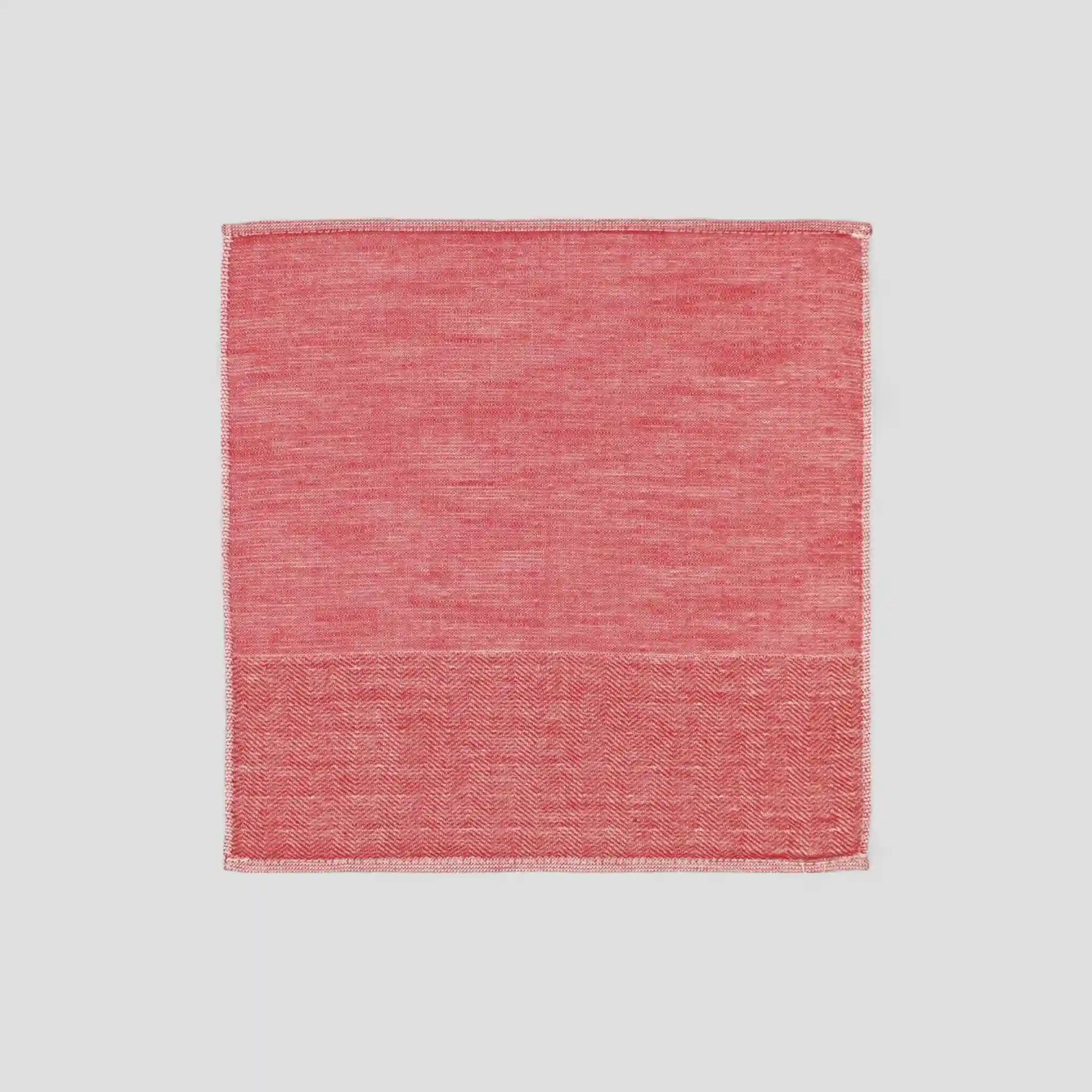 Red Imabari towel with a subtle herringbone pattern on a light gray background.