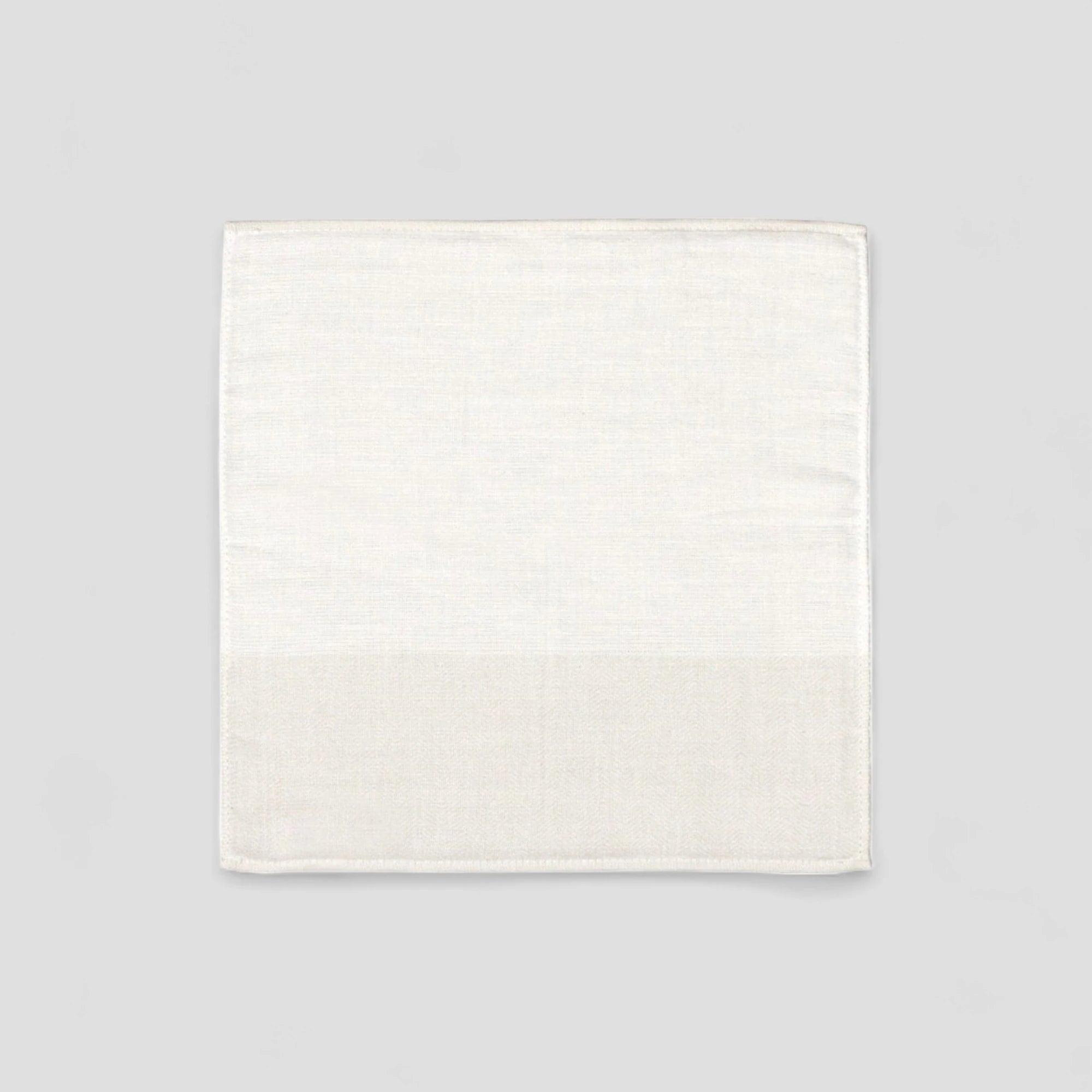 White Imabari towel with a subtle herringbone pattern on a light gray background.